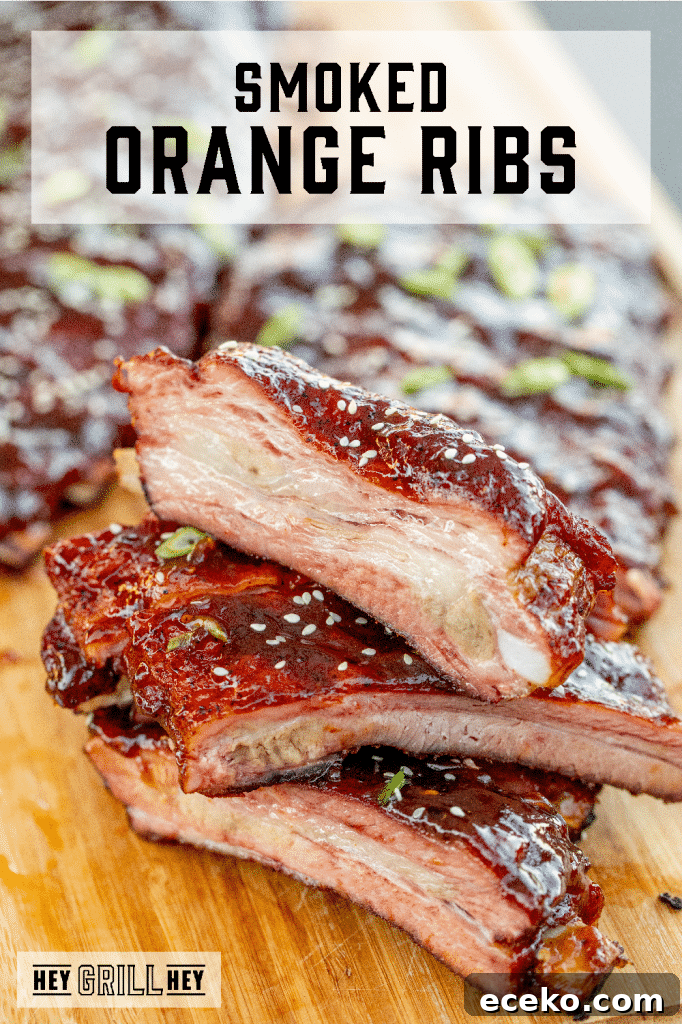 Sliced and stacked orange glazed ribs on a wooden cutting board with text overlay - Smoked Orange Ribs.