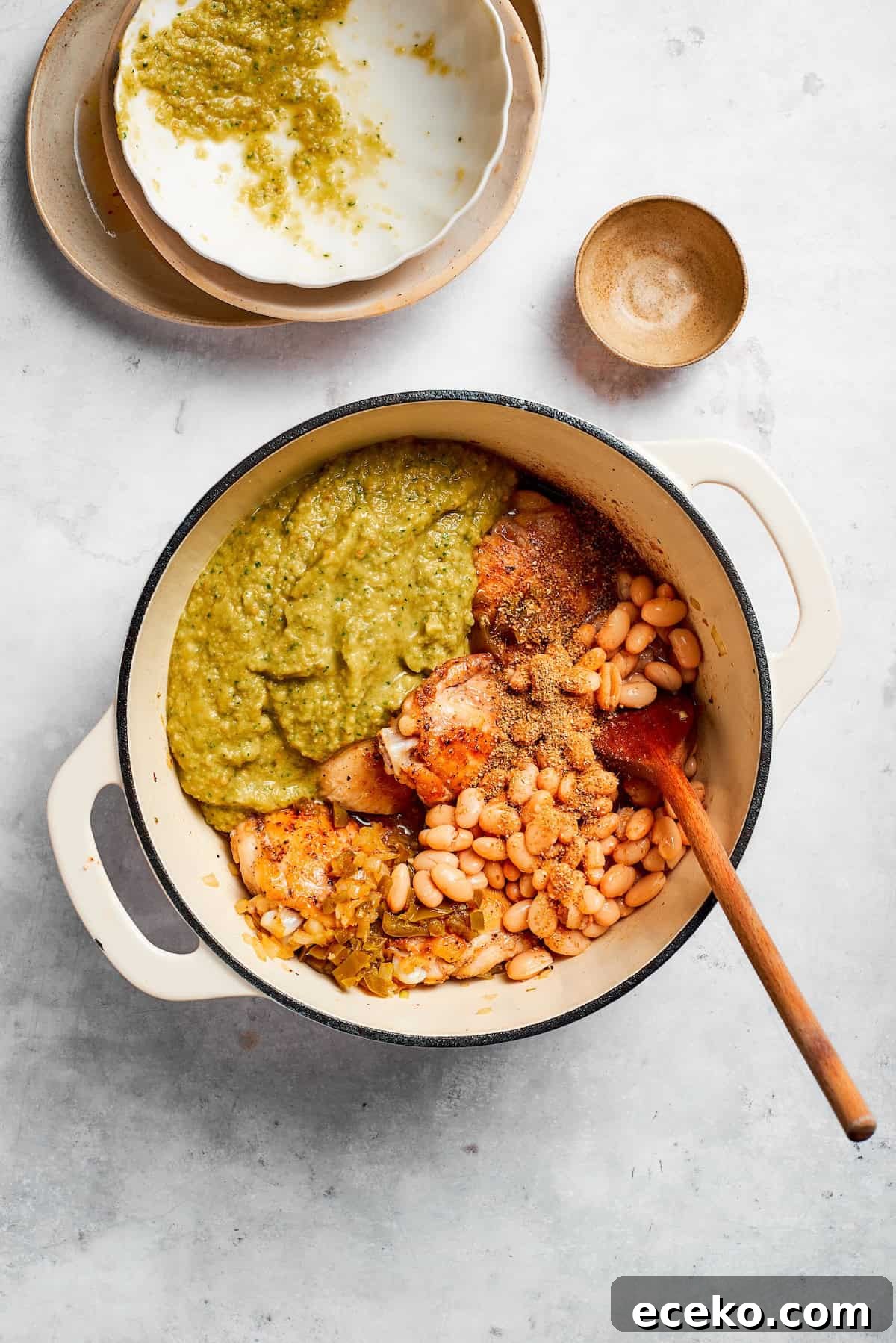 Add the beans, salsa, and stock. Ingredients for spicy chicken soup are added to a soup pot.