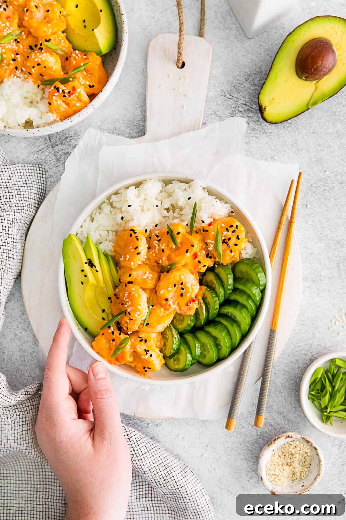 A hand holding a Bang Bang Shrimp Bowl. 