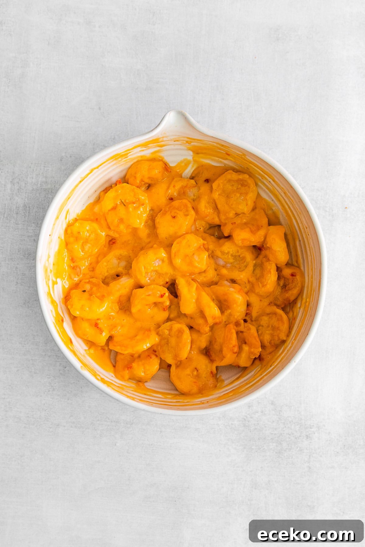 Fried shrimp tossed in bang bang sauce in a bowl. 