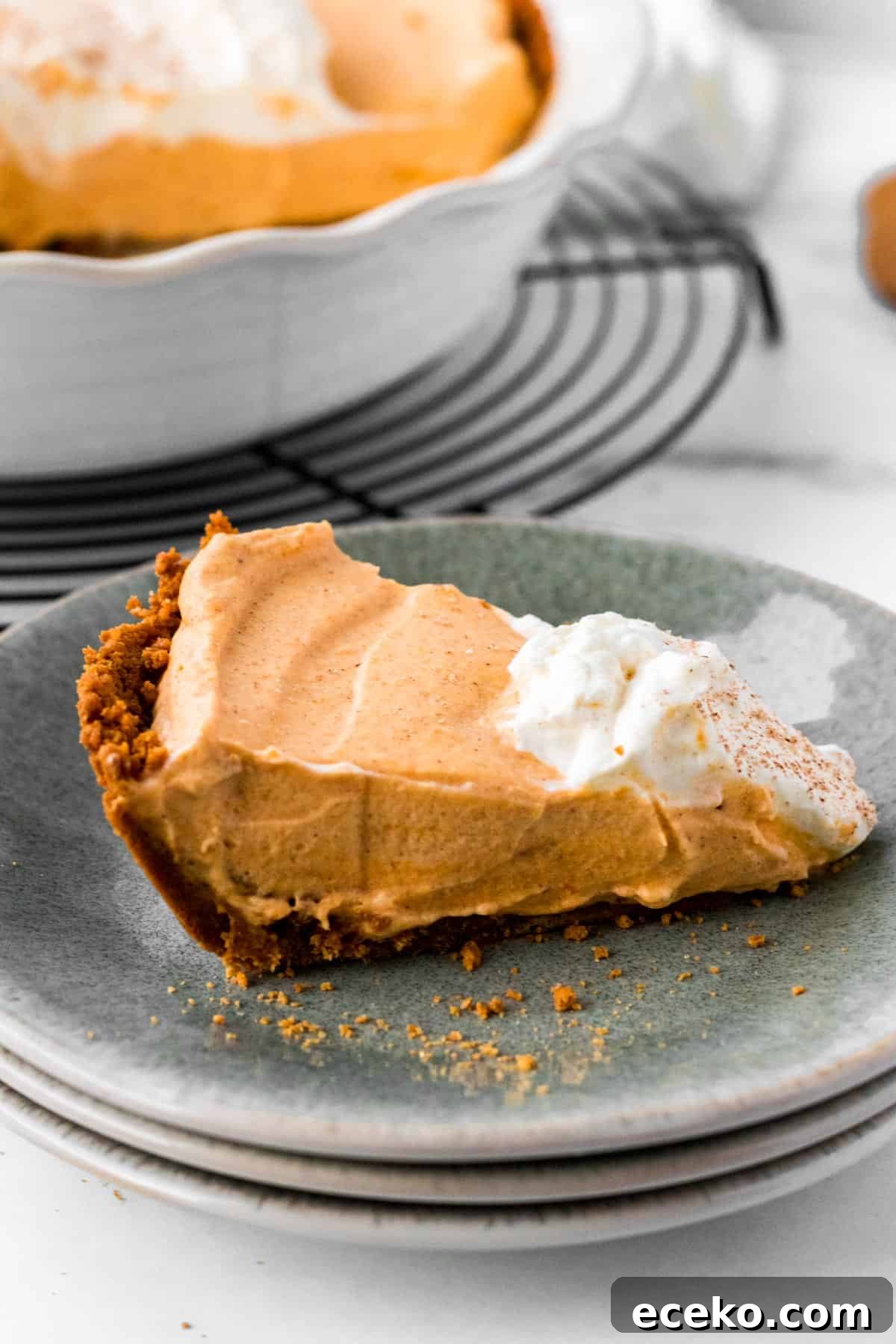Gingersnap Crust Pumpkin Mousse Pie: Creamy Autumn Dessert 4 slice of pumpkin mousse pie on stack of plates with full pie in background