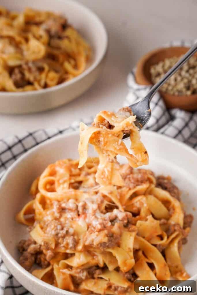 fork with bite of crock pot ground beef and noodles