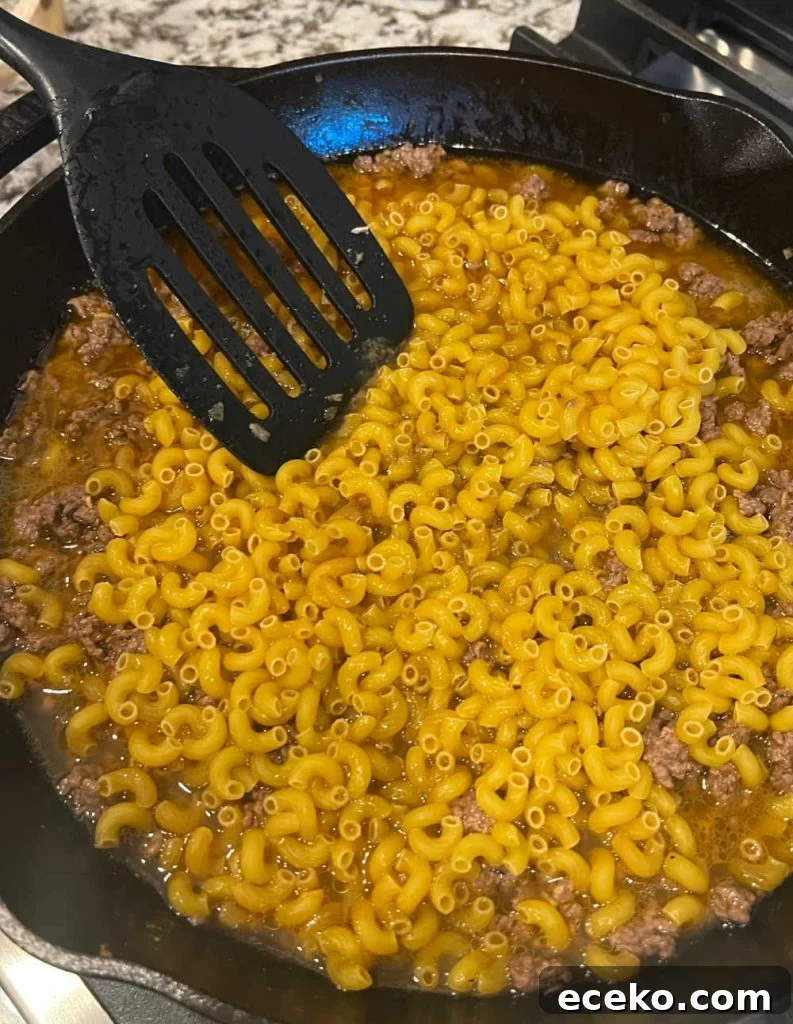 cook pasta in beef broth in skillet.