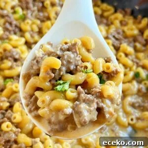 homemade cheeseburger macaroni hamburger helper on a white serving spoon.