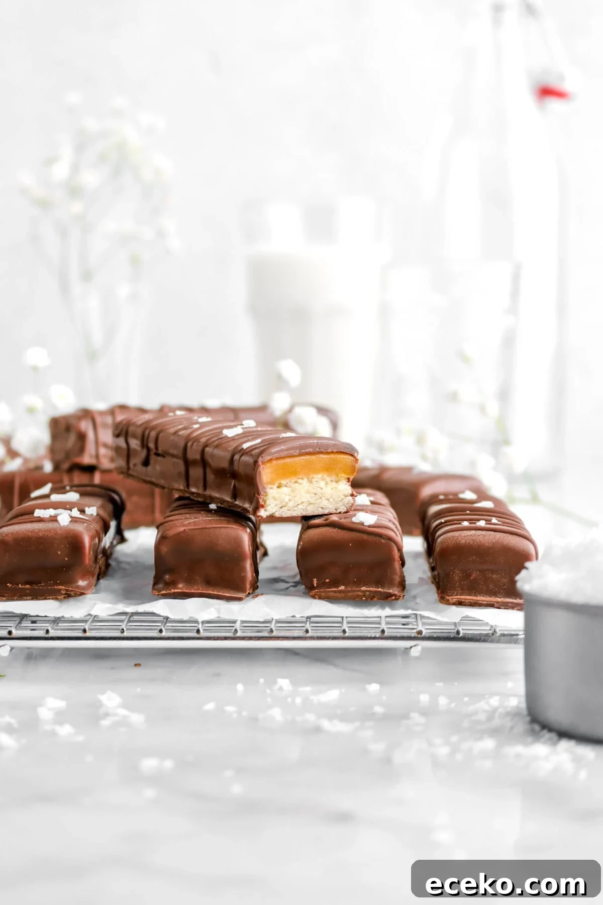 Homemade Twix Bars Recipe: Crispy Caramel Chocolate Cookies 2 four twix bars on wire cooling rack with one stacked on top and cut open