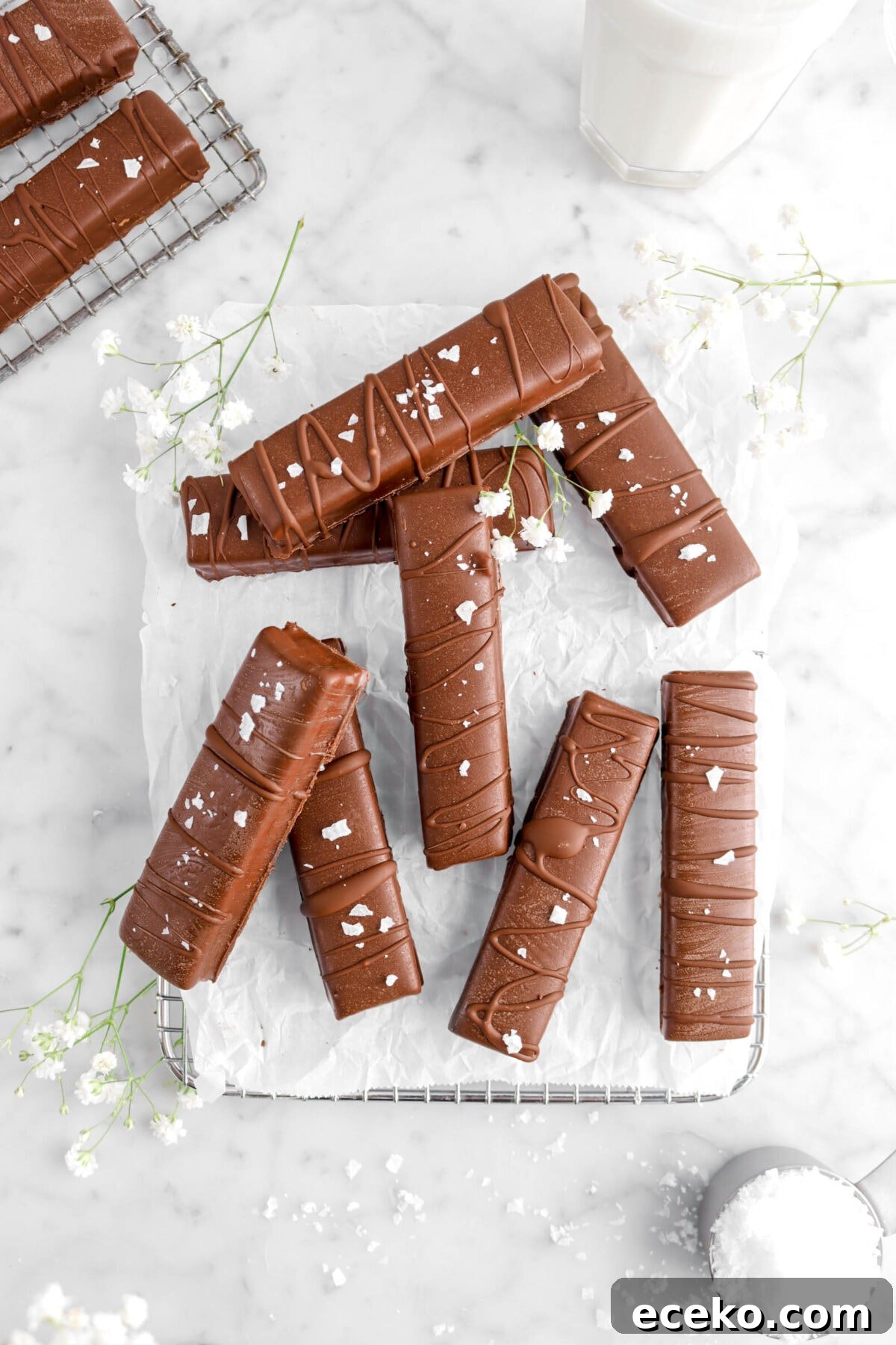 Homemade Twix Bars Recipe: Crispy Caramel Chocolate Cookies 11 overhead shot of eight candy bars with flowers and glass of milk