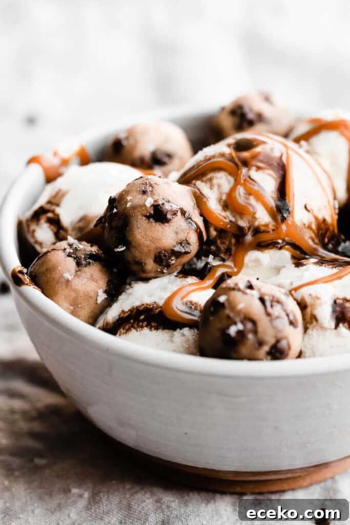 No-Bake Edible Cookie Dough Bites Recipe for Parties 9 A bowl of ice cream topped with caramel and chocolate sauce, and cookie dough bites.
