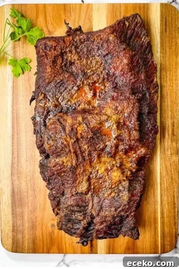 A smoked brisket on a wooden cutting board.