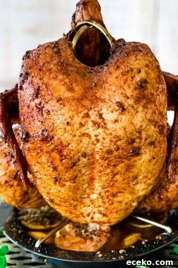 A smoked whole chicken sitting upright in a holder.