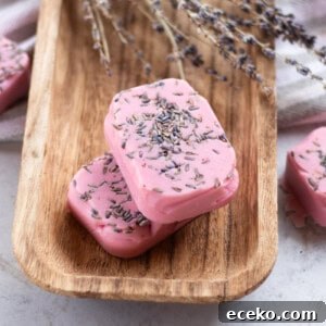 Homemade lavender soap bars with dried lavender buds curing on a wooden drying rack.