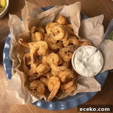 Creole-Style Tomato Shakshuka 6 A blue basket of crispy fried shrimp with a small bowl of tartar sauce.