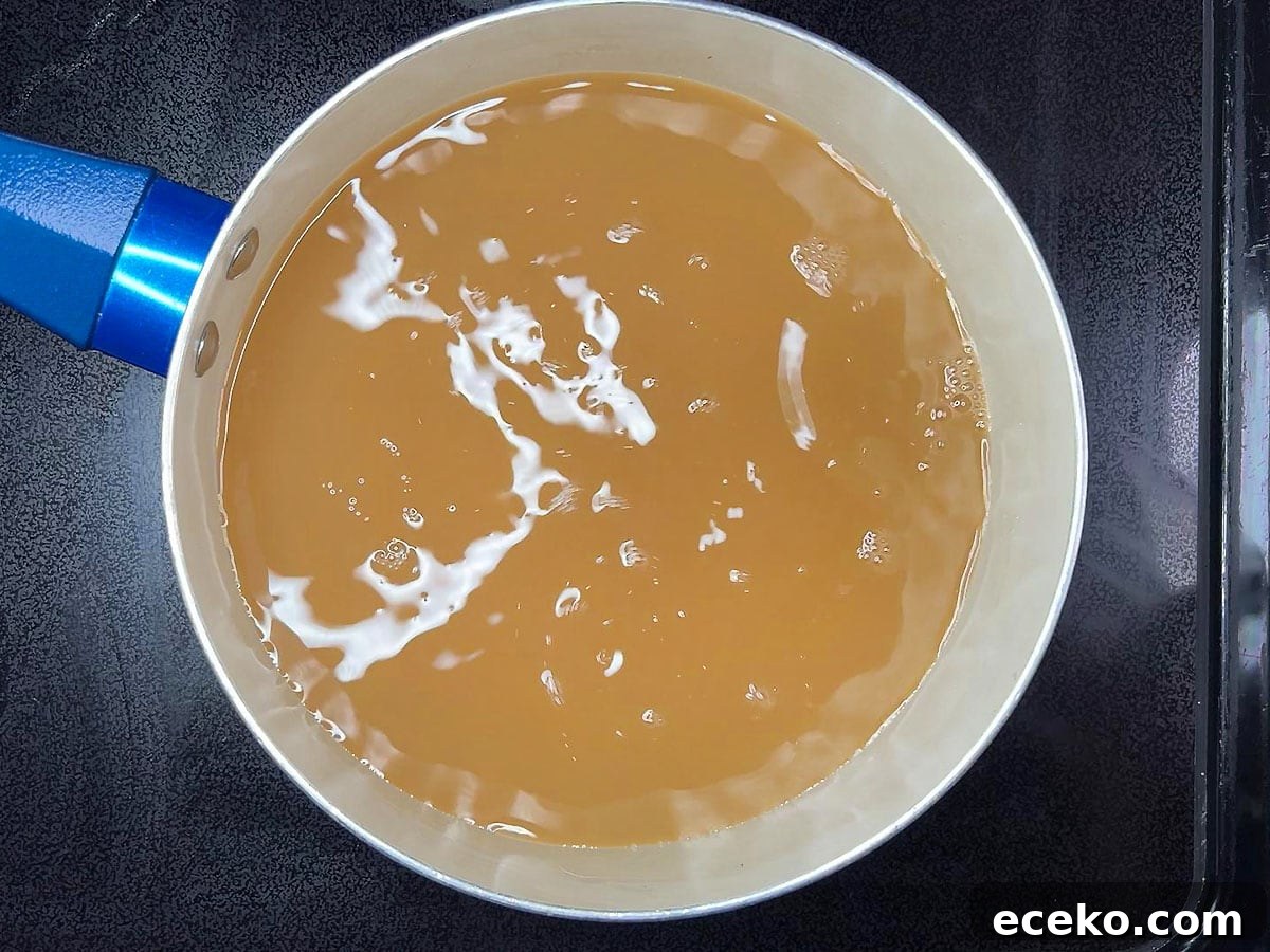 Bringing four cups of apple cider to a boil in a medium saucepan.