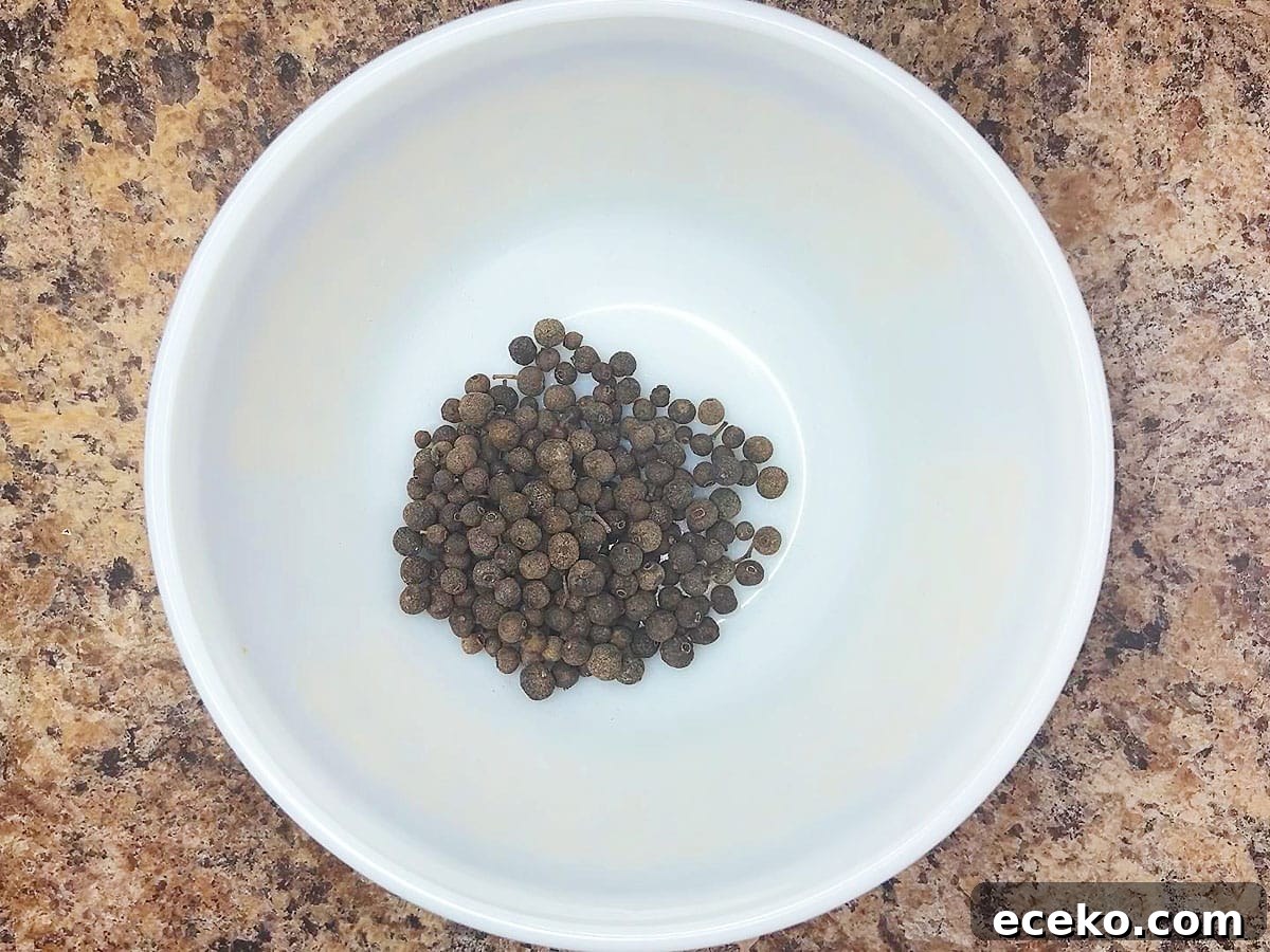 Whole allspice berries in a small mixing bowl.