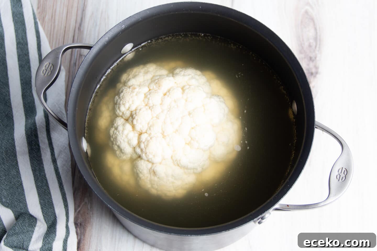 Picture of cauliflower in big pot filled with broth.