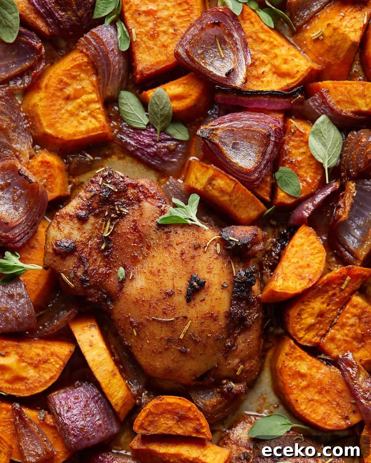 Up close overhead image of sheet pan chicken and sweet potatoes.