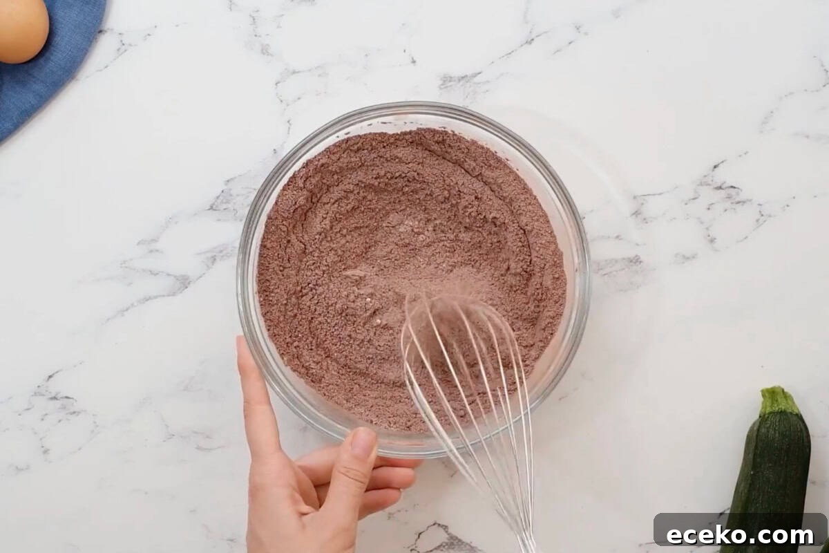 dry ingredients for chocolate cupcakes in a glass bowl with a whisk.