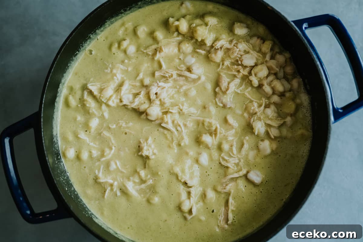 pot of pozole verde simmering on a stove.