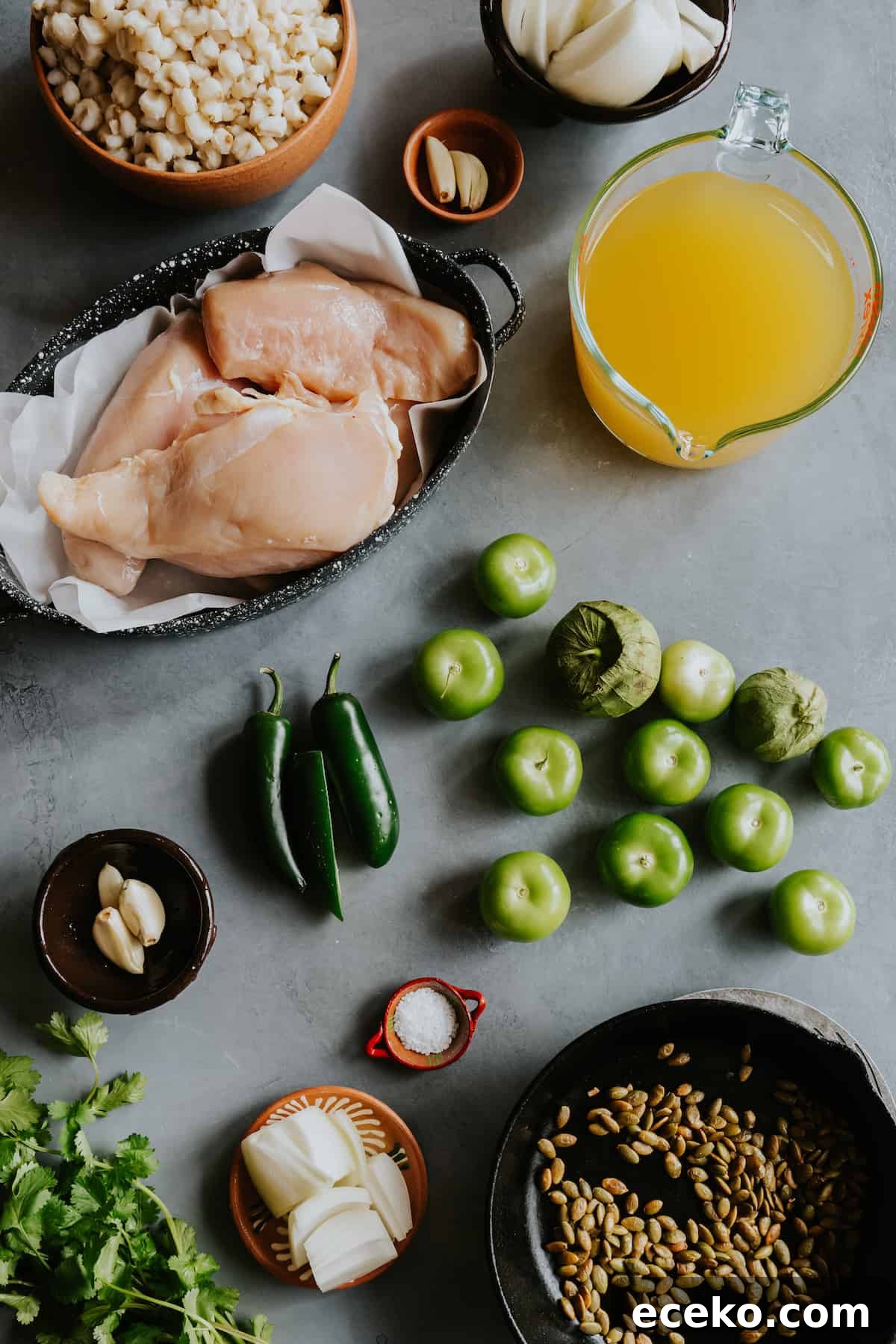 flat lay shot of the ingredients needed to make pozole verde with chicken measured out on a grey table.