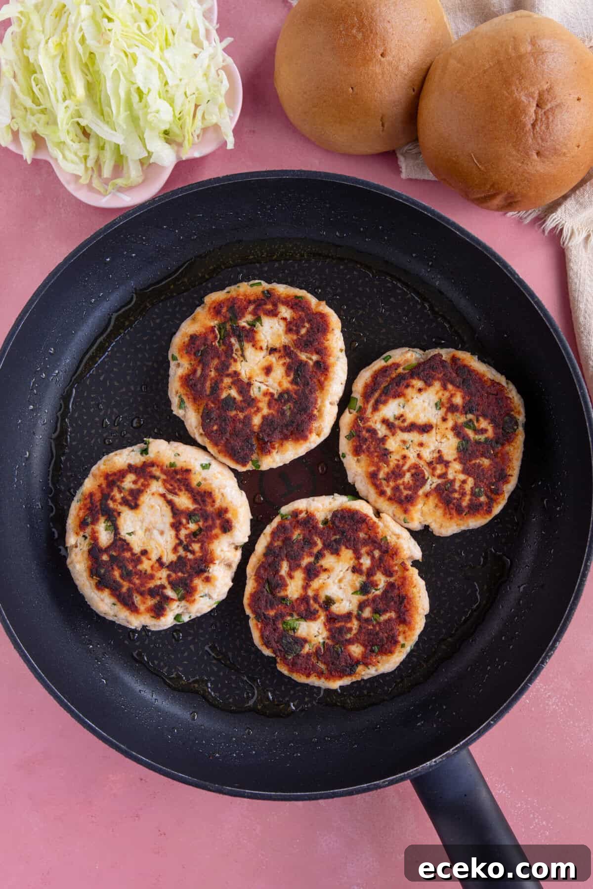 Process shot for chicken mince burgers showing the cooked chicken burger patties in a pan.
