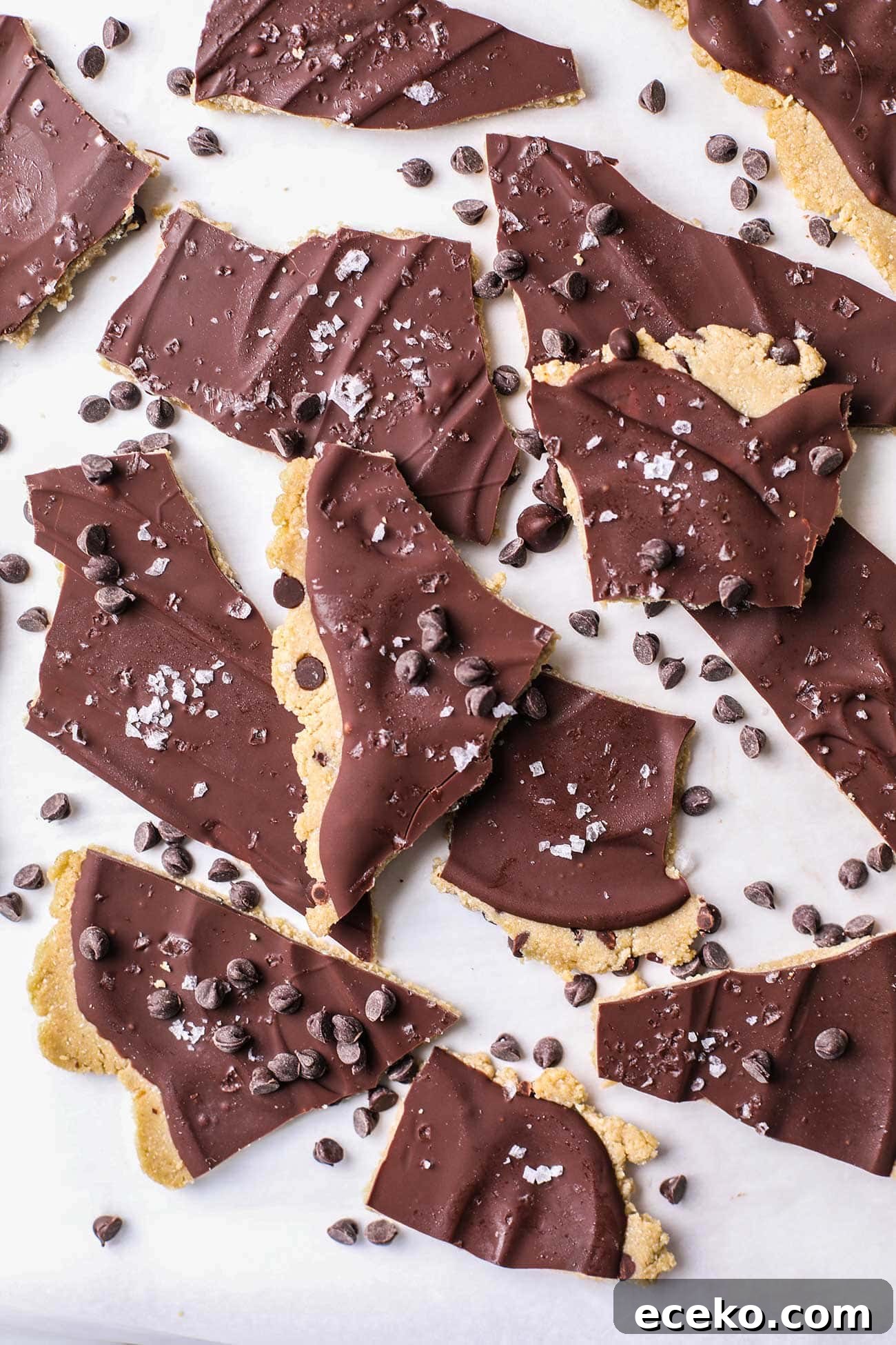 Pieces of protein cookie dough bark shown with mini chocolate chips around the pieces.