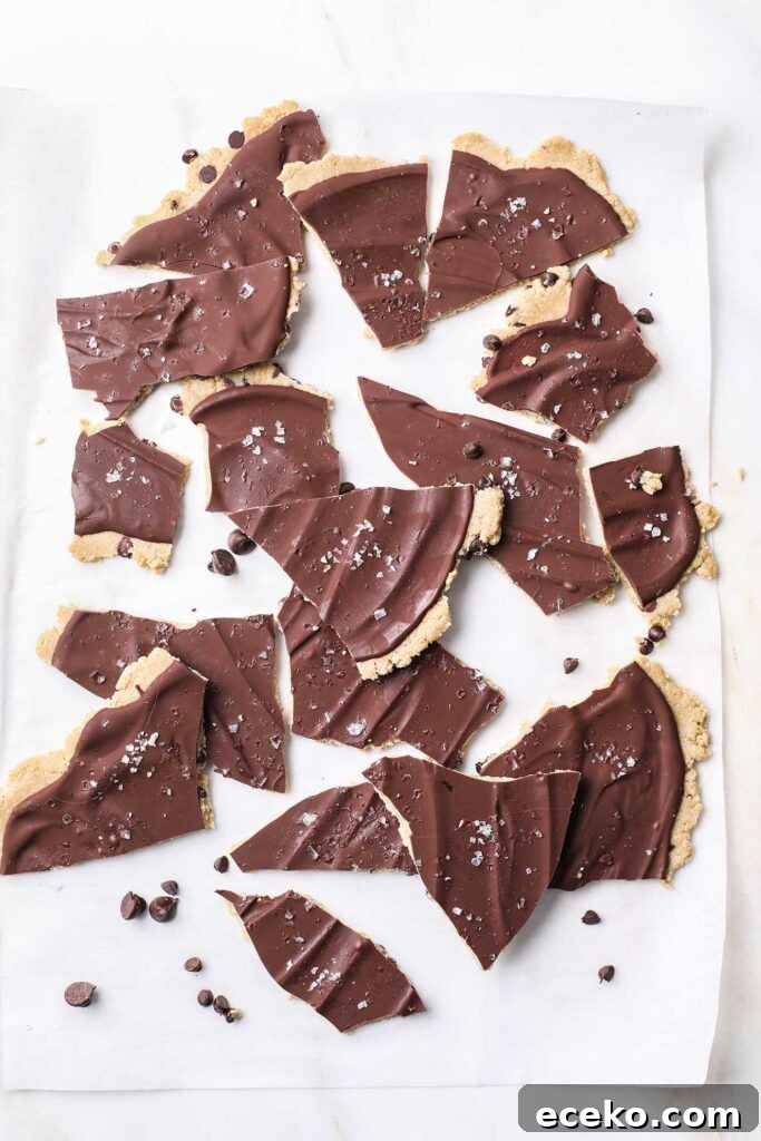 Frozen cookie dough bark being broken into smaller pieces.