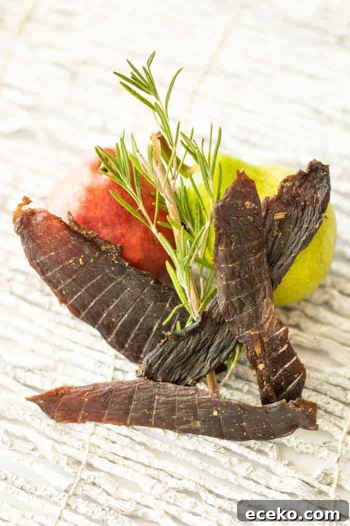 Rosemary-Pear Venison Jerky Recipe for Flavorful Snacks 2 Rosemary and a pear with deer jerky on white background