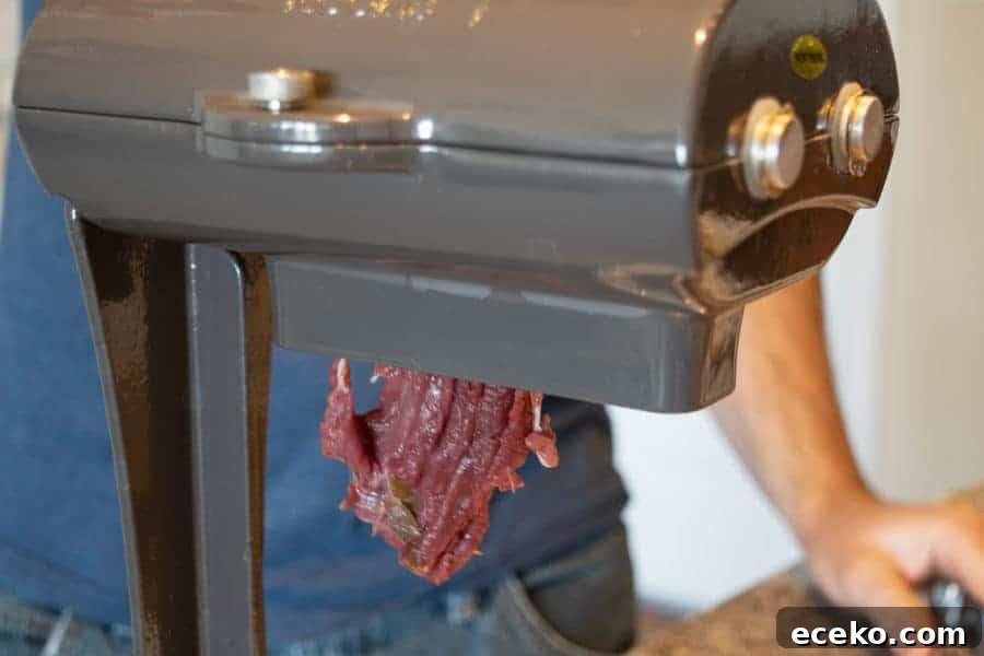 Rosemary-Pear Venison Jerky Recipe for Flavorful Snacks 6 Venison being sliced by a jerky meat slicer