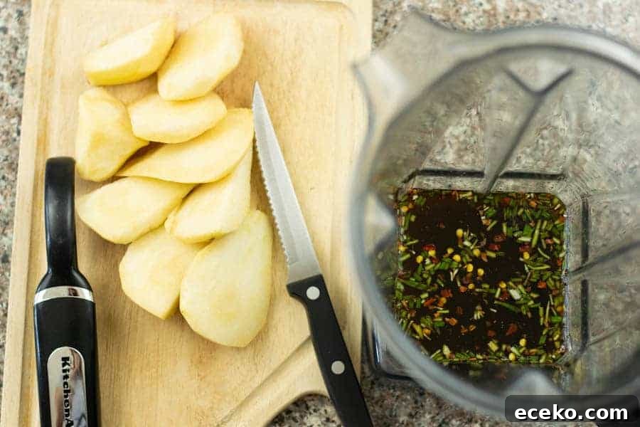 Rosemary-Pear Venison Jerky Recipe for Flavorful Snacks 7 sliced rosemary on cutting board with blender next to it with liquid ingredients