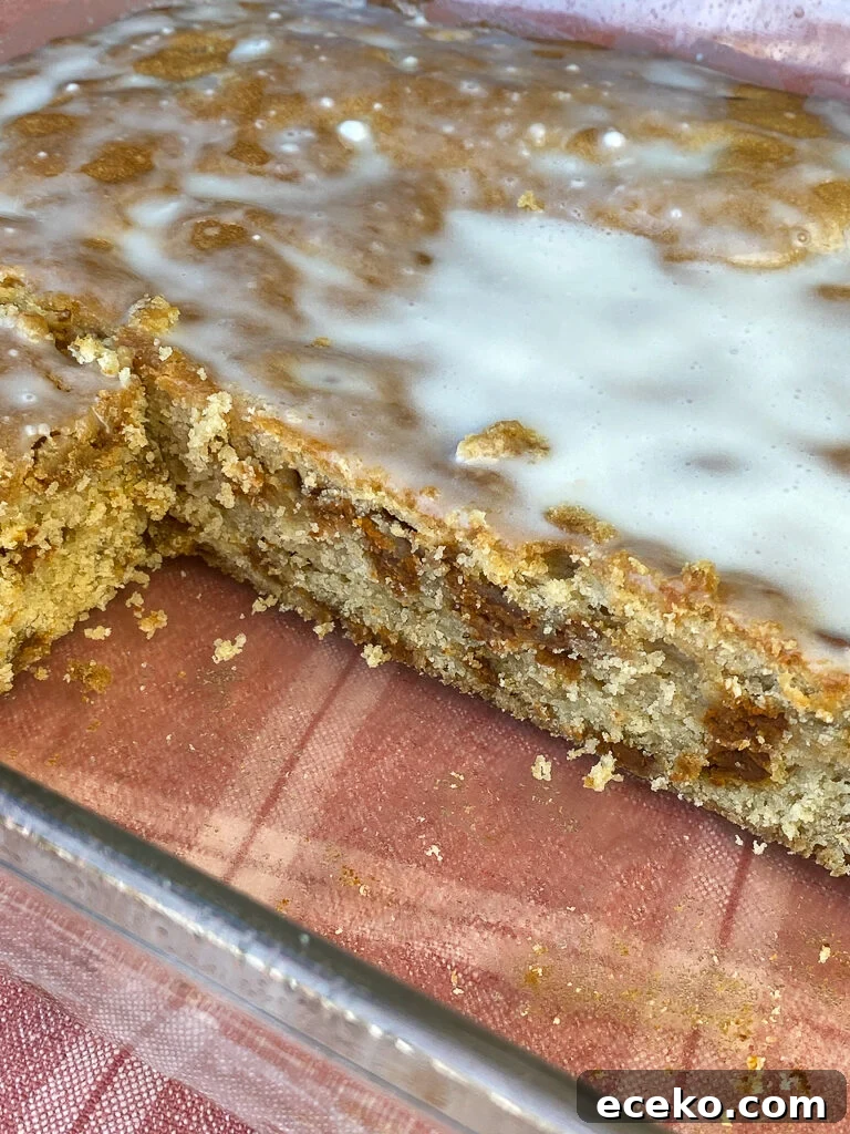 Cinnamon Applesauce Cake Recipe with Moist Spice and Quick Prep 11 Generous layer of confections sugar icing on a cinnamon applesauce coffee cake in a 9x13" baking dish on a red plaid napkin