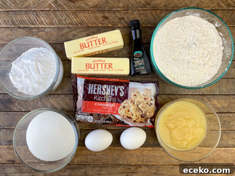 Cinnamon Applesauce Cake Recipe with Moist Spice and Quick Prep 4 Ingredients to make homemade applesauce coffee cake on a wooden counter top are butter, vanilla extract, flour, applesauce, eggs, cinnamon chips, granulated sugar and confectioners sugar