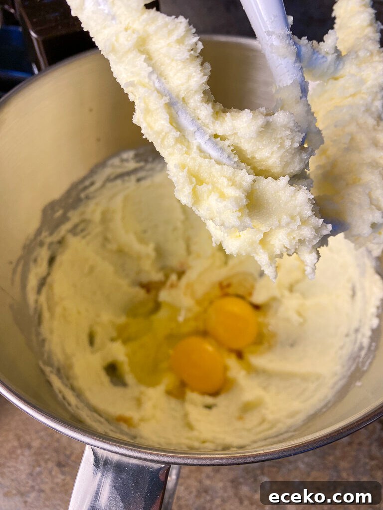 Cinnamon Applesauce Cake Recipe with Moist Spice and Quick Prep 7 Beater with creamed butter and sugar sitting above a mixing bowl with eggs fresh cracked into the sugar mixture