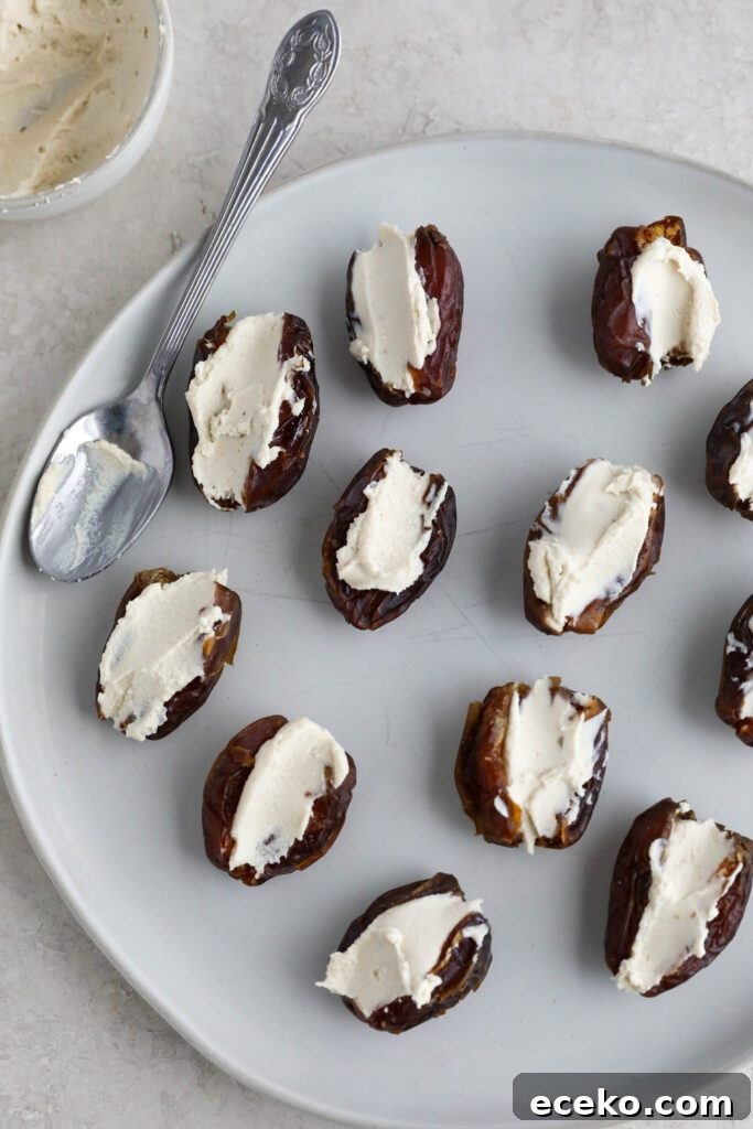 Dates with cream cheese in the center on plate with spoon