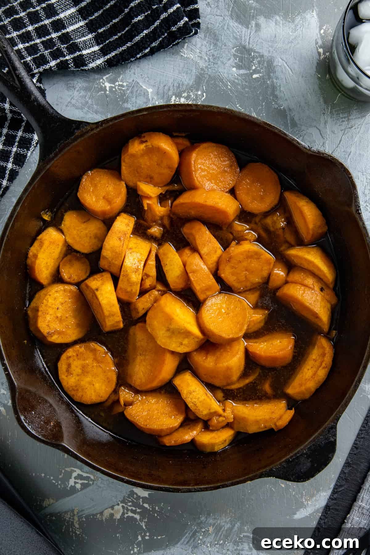 Cooked candied sweet potatoes in a cast iron skillet.