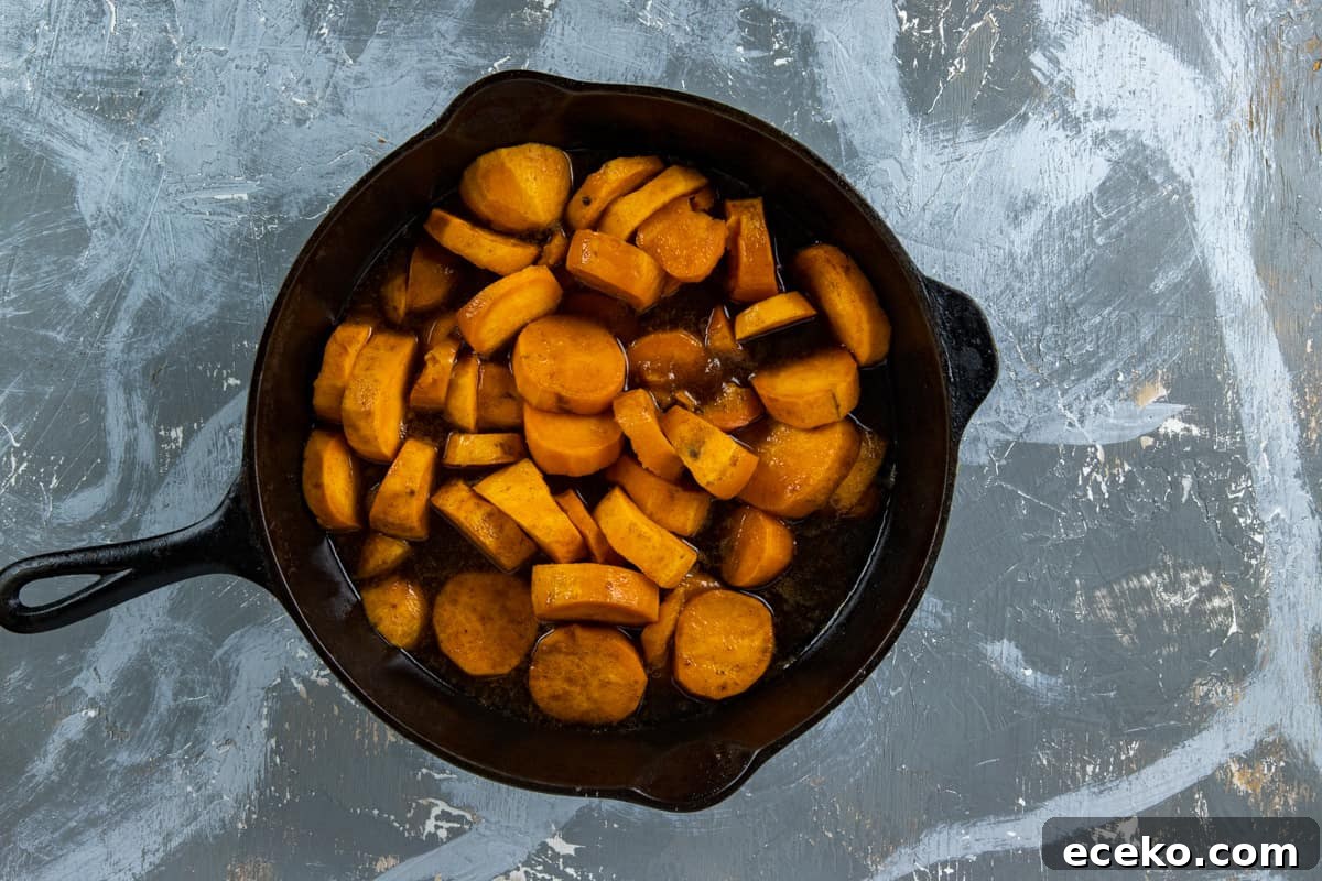 Uncooked sliced sweet potatoes, butter, and seasonings in skillet.