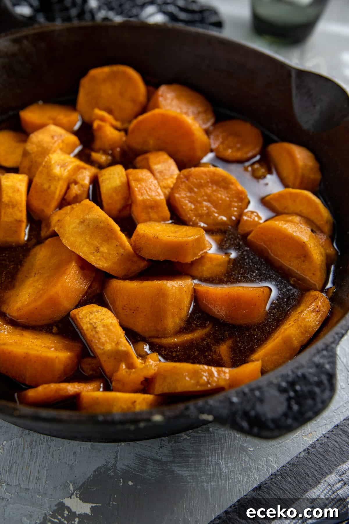 Cooked candied sweet potatoes in a cast iron skillet.