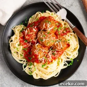 italian meatballs with marinara sauce over spaghetti on a plate