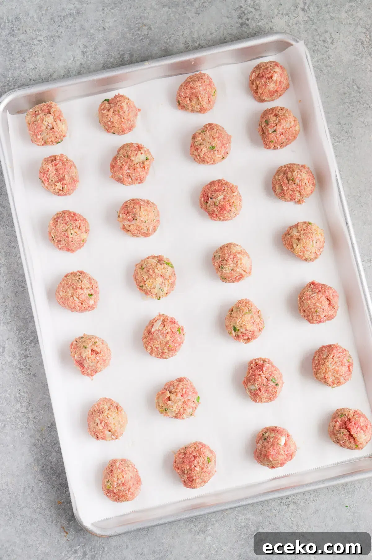 formed raw meatballs on a baking sheet