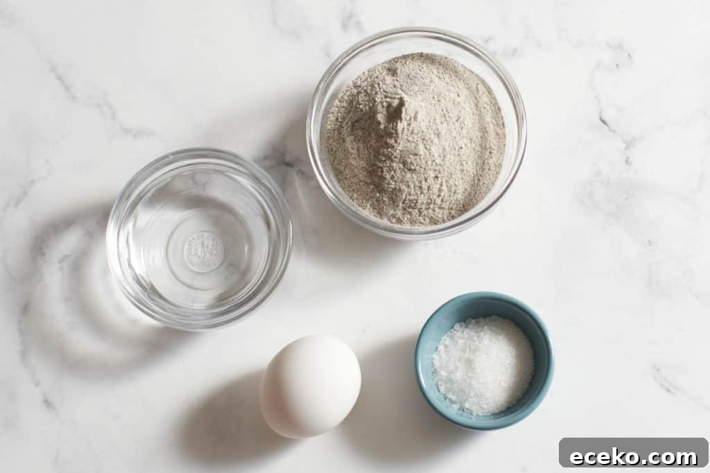 One egg and small bowls of water, buckwheat flour, and salt.