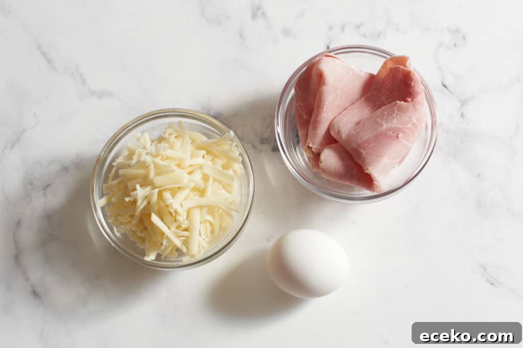 One egg and two small bowls of grated cheese and ham slices.