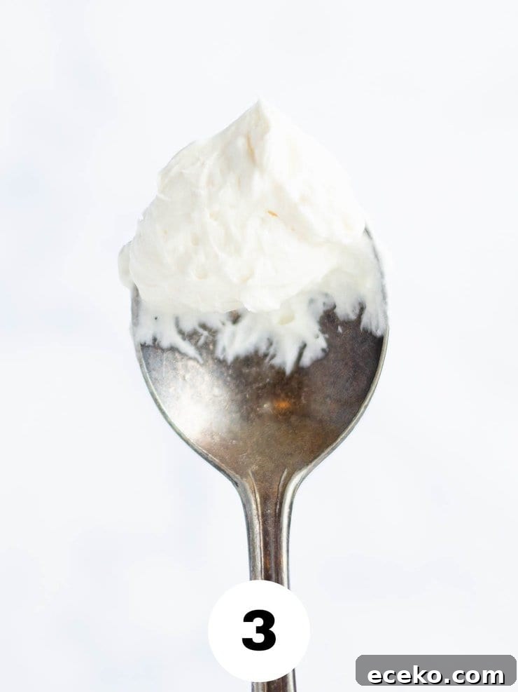Marshmallow buttercream frosting on a silver spoon.