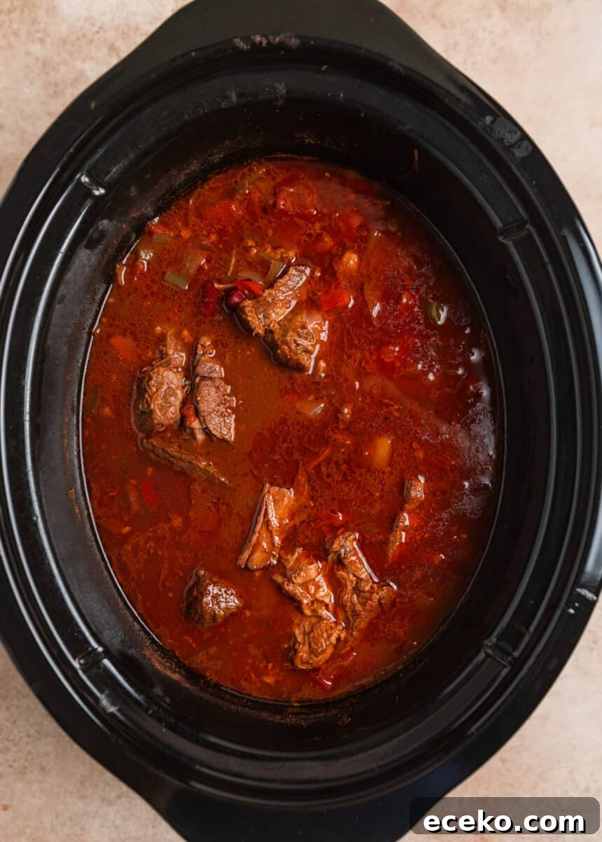 Cooked slow cooker chili before beef is shredded.