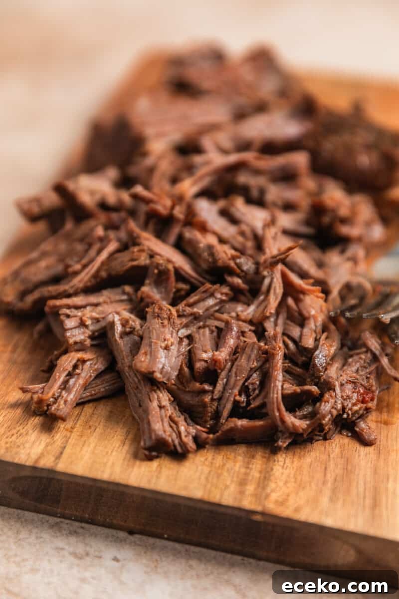 Shredded beef on cutting board.