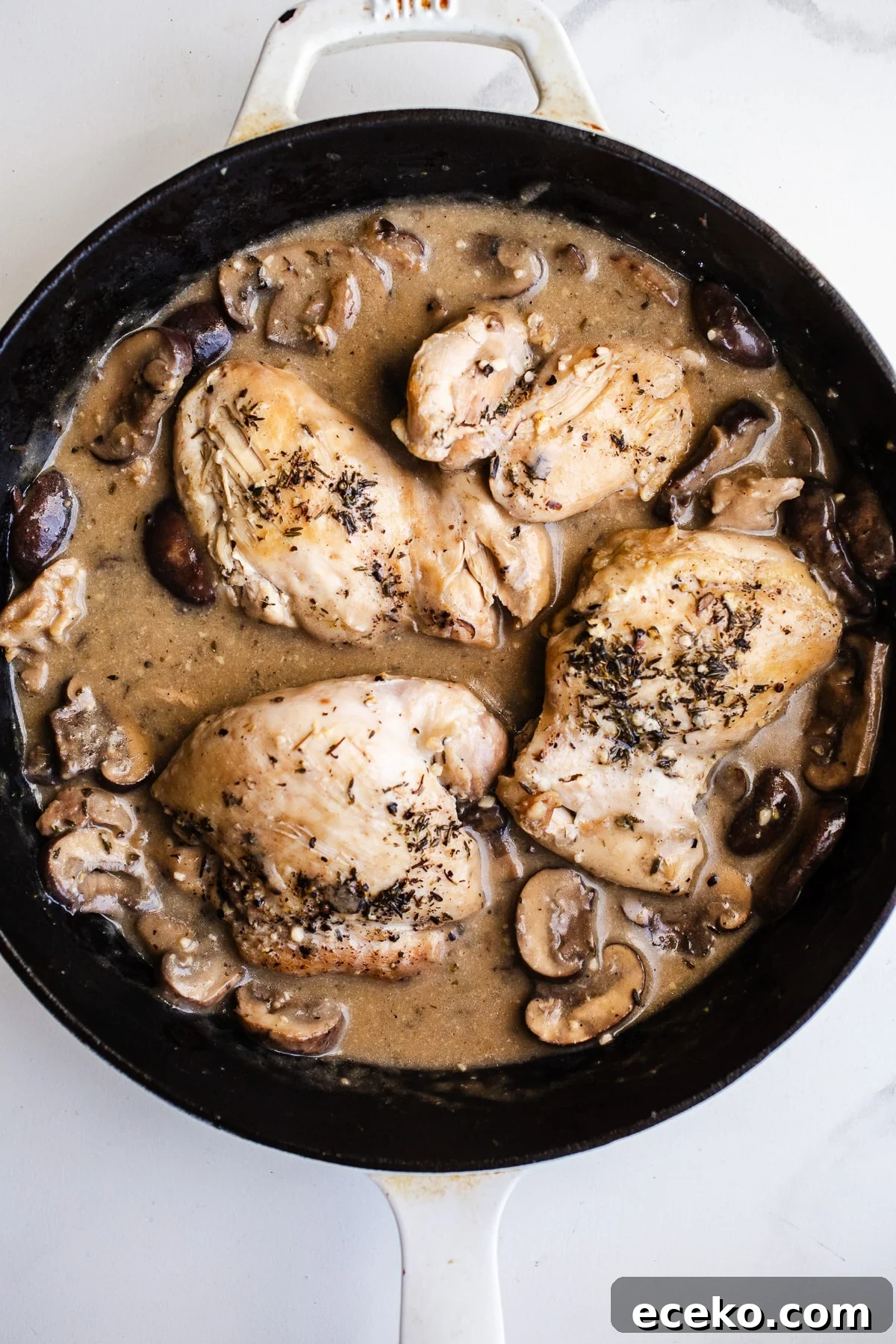 Chicken and mushrooms in a skillet.