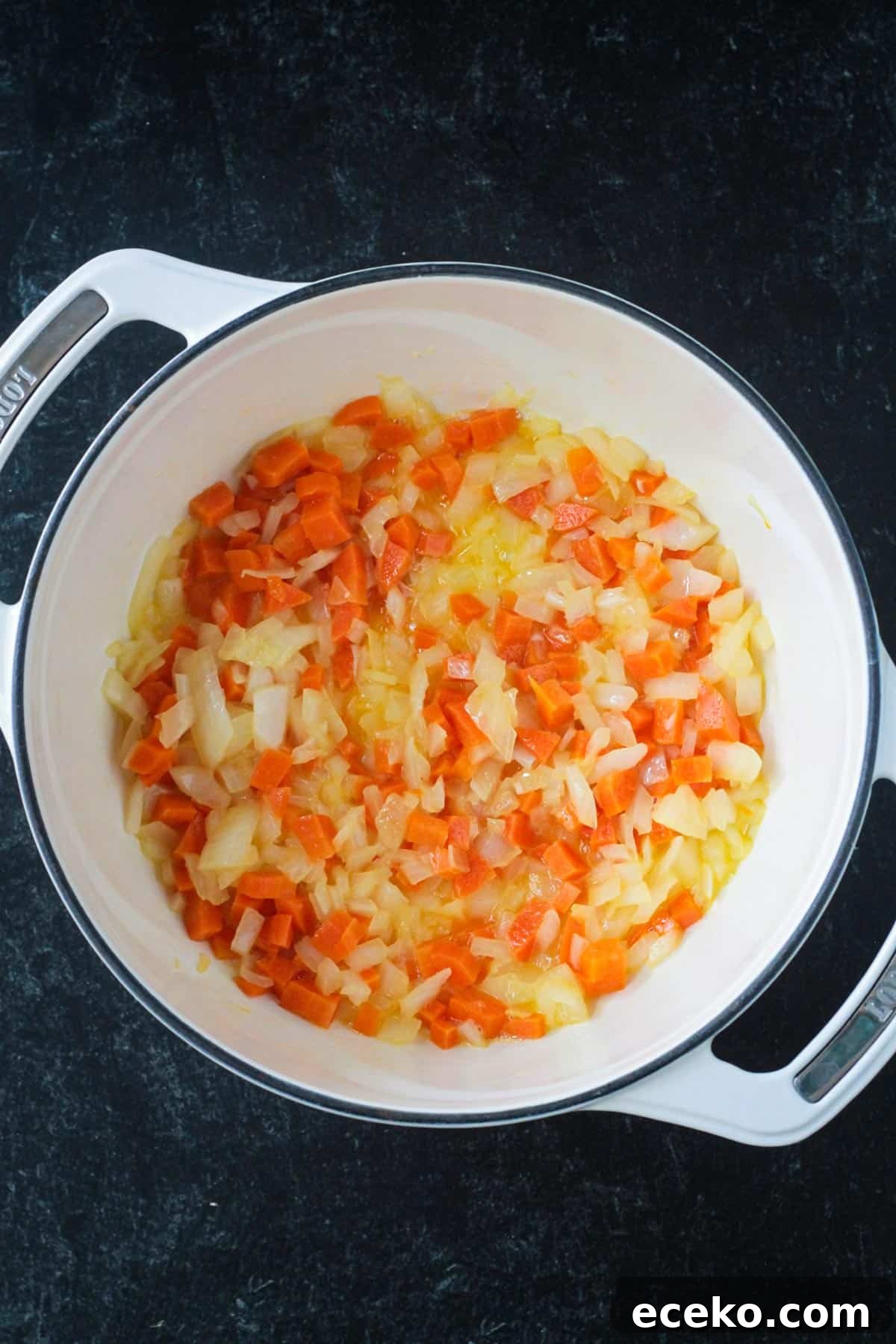 Creamy Coconut Curry Corn Soup Recipe 4 Onions and carrots sautéed in pot.