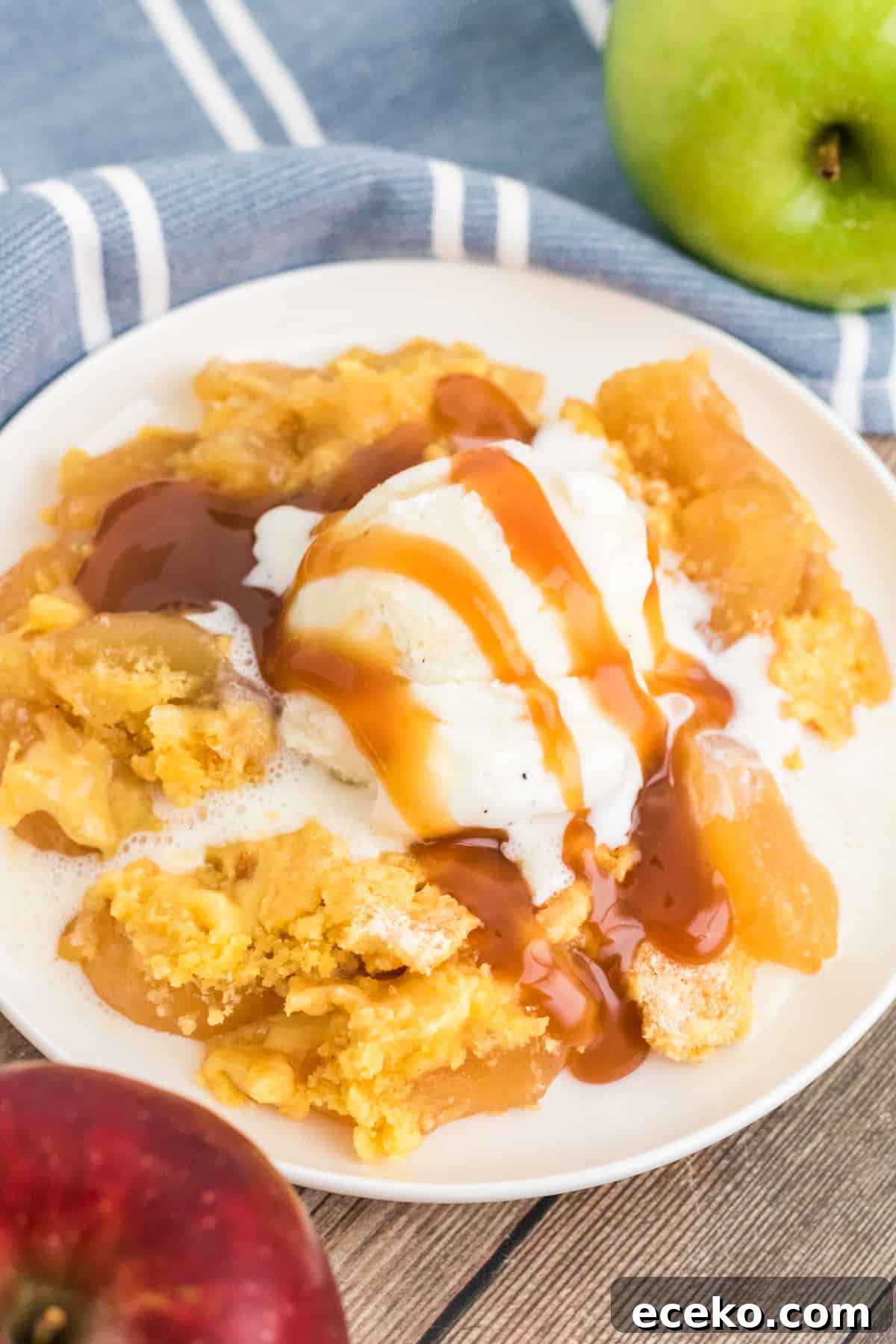 3-Ingredient Apple Dump Cake Recipe: Quick Crowd-Pleasing Dessert 2 Apple dump cake with scoop of vanilla ice cream and drizzles with caramel sauce.