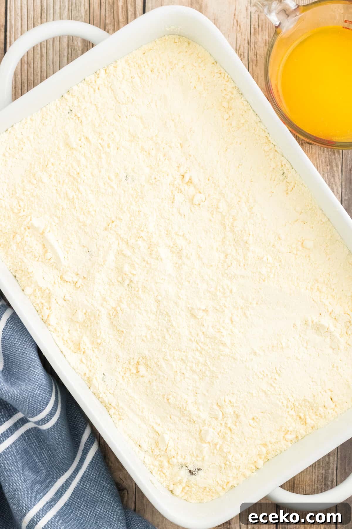 3-Ingredient Apple Dump Cake Recipe: Quick Crowd-Pleasing Dessert 6 Cake mix covering pie filling in baking dish.