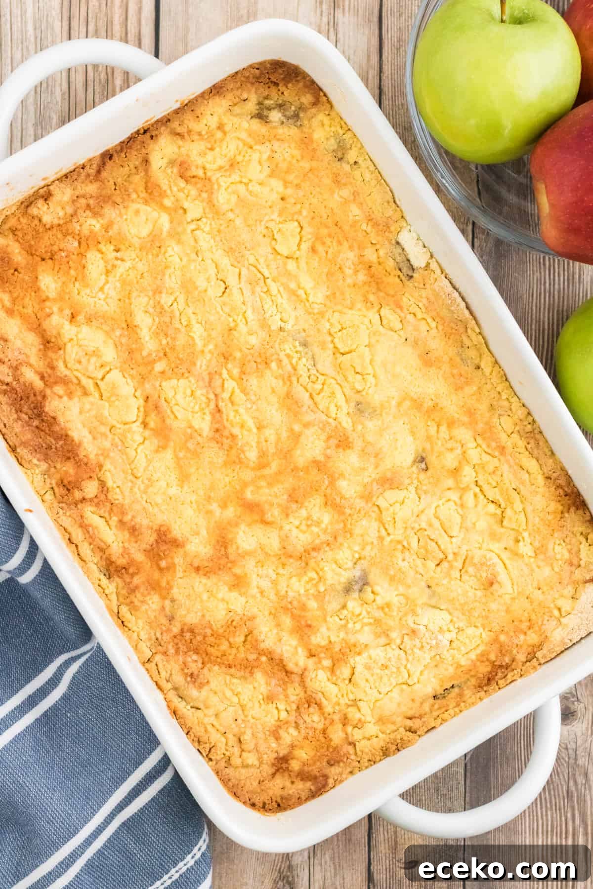 3-Ingredient Apple Dump Cake Recipe: Quick Crowd-Pleasing Dessert 8 Apple Dump Cake in white 9 x 13 casserole dish.