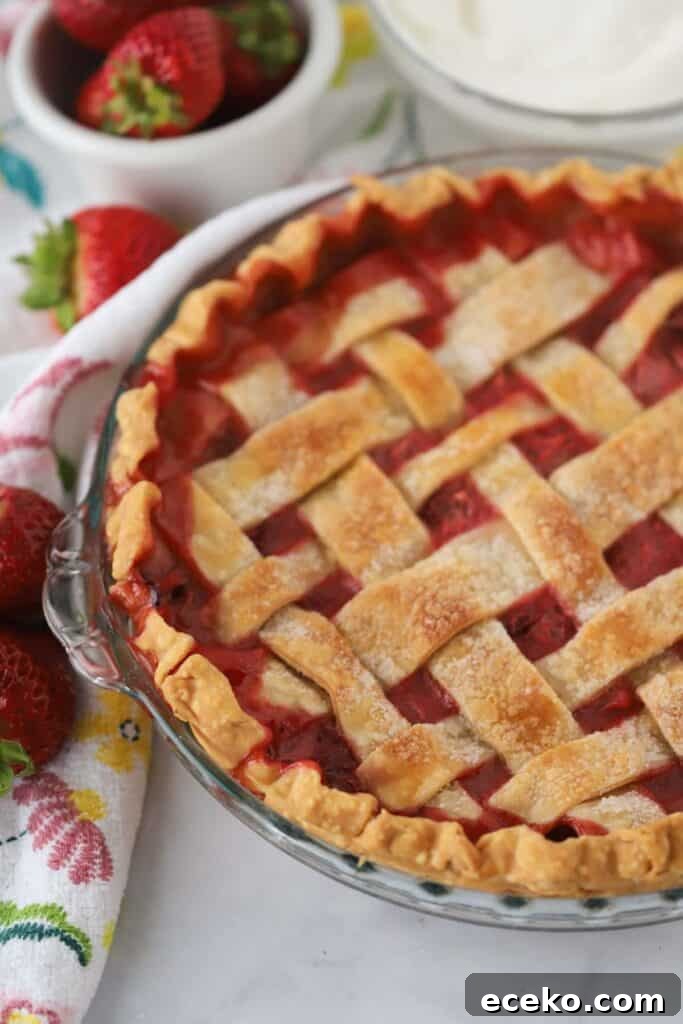 Our easy strawberry rhubarb pie recipe in a pie plate with a lattice top.