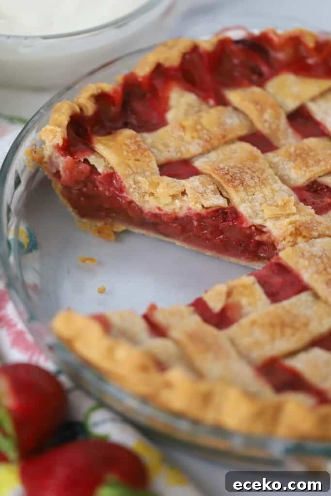 A slice taken out of a strawberry rhubarb pie.