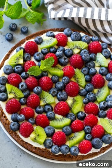 Brownie pizza topped with cream cheese frosting and fresh fruit.